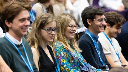 Photo of 5 scholars watching a talk