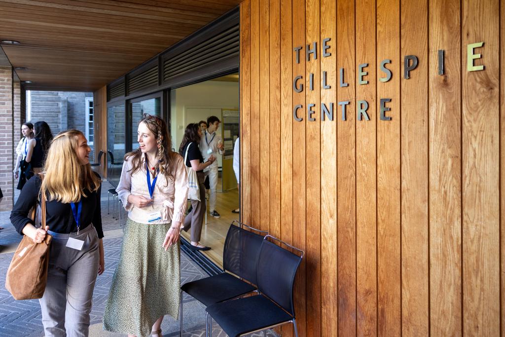 Two scholars talk while walking into the Gillespie centre. 